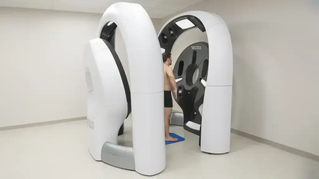 Vectra 3D Imaging System device with dual white camera towers capturing a patient’s full-body 3D scan in a clinical setting